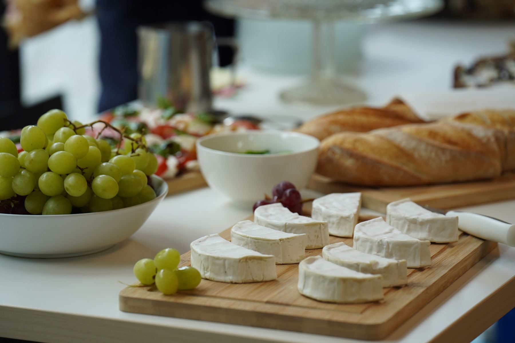 Catering mit Käse, Trauben und frischem Baguette