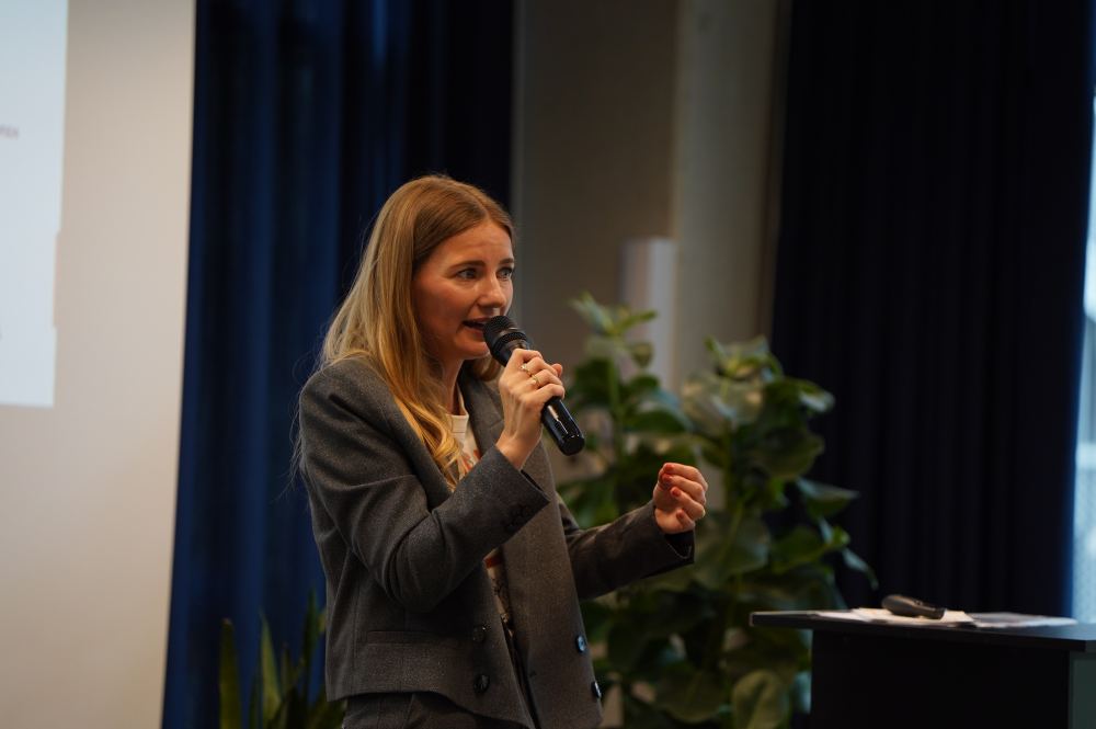 Speakerin im Business-Blazer spricht engagiert ins Mikrofon